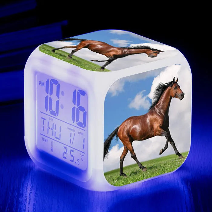 Small square plastic LED alarm clock showing time and temperature on its display.