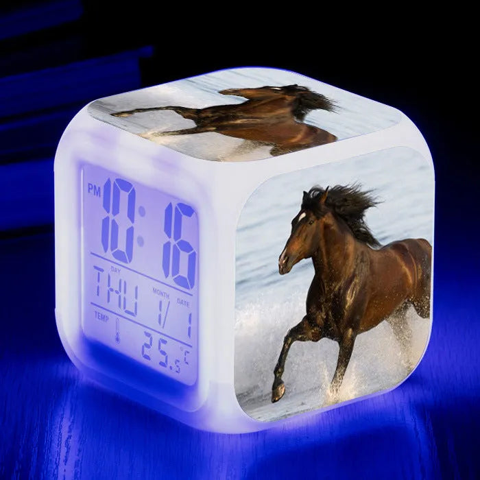 Small square plastic LED alarm clock showing time and temperature on its display.