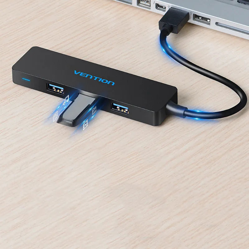 Black four-port USB 3.0 hub with a short integrated cable on a desk