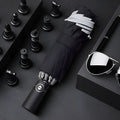 Black automatic reverse folding umbrella shown open, demonstrating its 10-rib canopy structure and plastic non-slip handle.