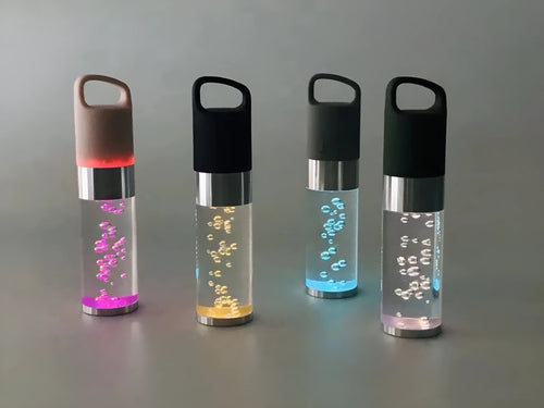 Compact colourful Bluetooth speaker with crystal light feature in pink, black, silver, or green.