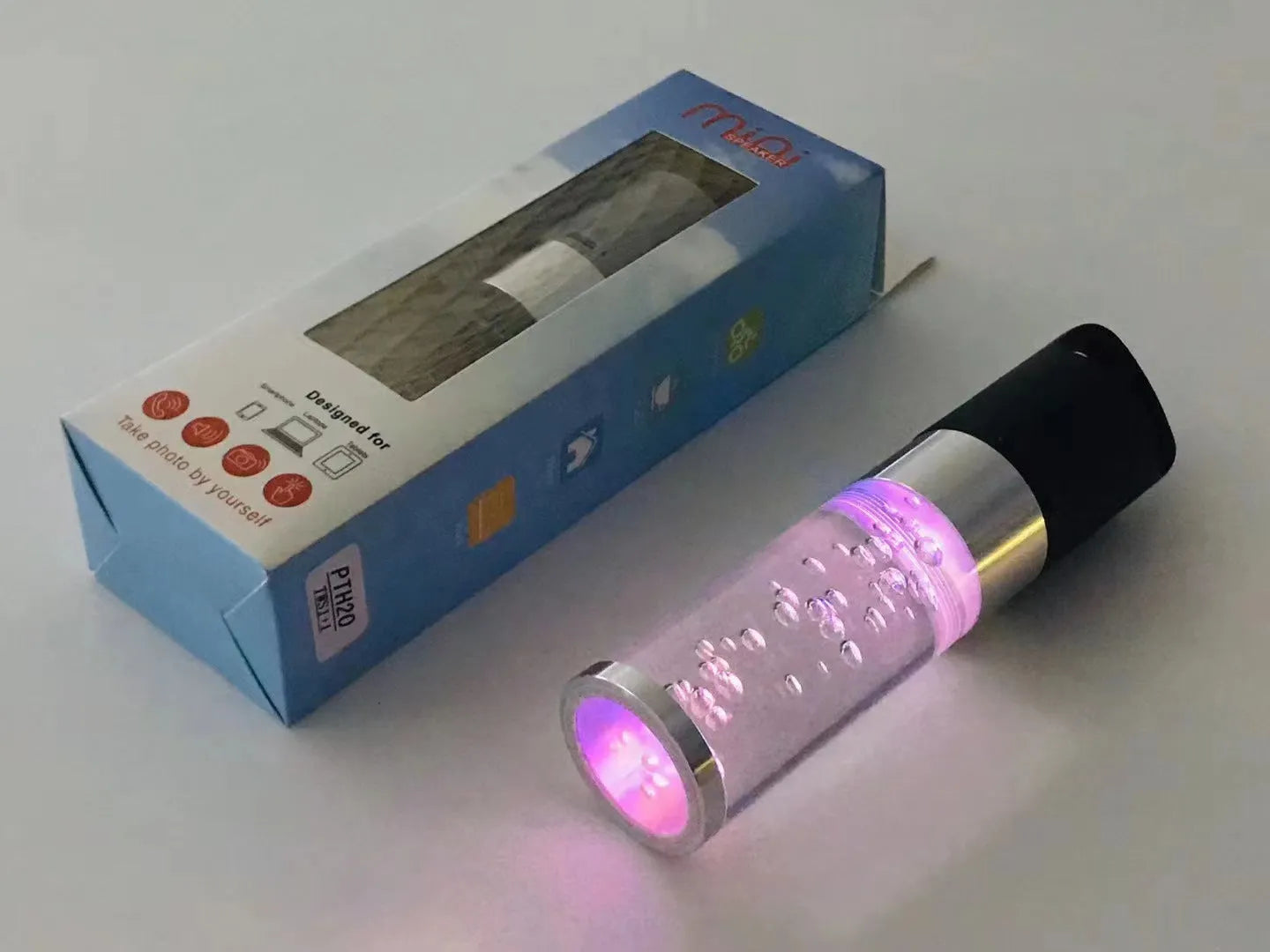 Compact colourful Bluetooth speaker with crystal light feature in pink, black, silver, or green.