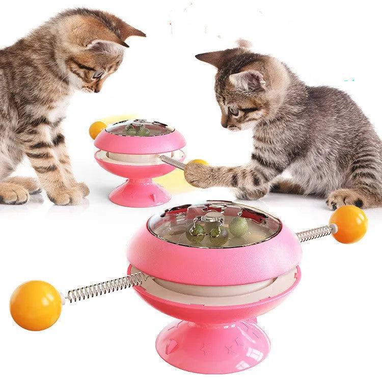 Rotatable cat toy with colourful turntable, stick elements, and transparent top holding catnip balls on a suction cup base.