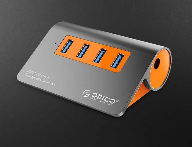 Dark grey USB-C laptop hub with four orange-accented USB 3.1 ports and separate data cable