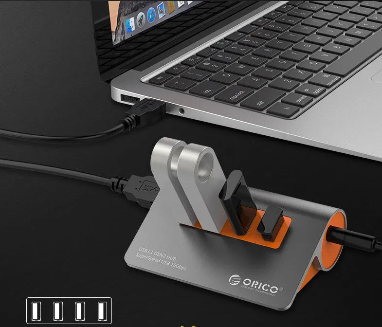 Dark grey USB-C laptop hub with four orange-accented USB 3.1 ports and separate data cable
