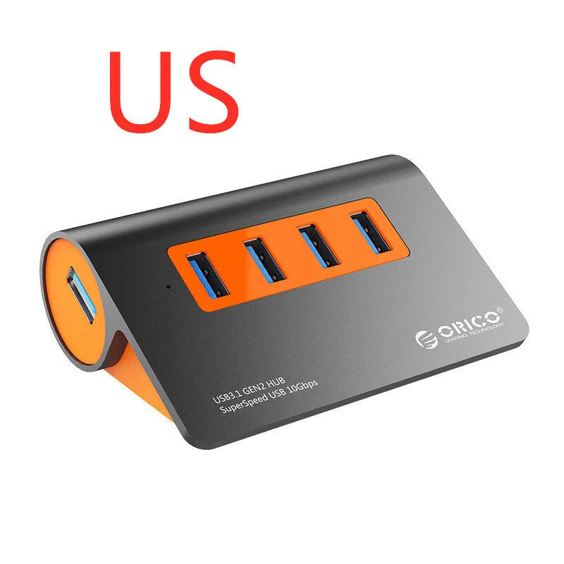 Dark grey USB-C laptop hub with four orange-accented USB 3.1 ports and separate data cable