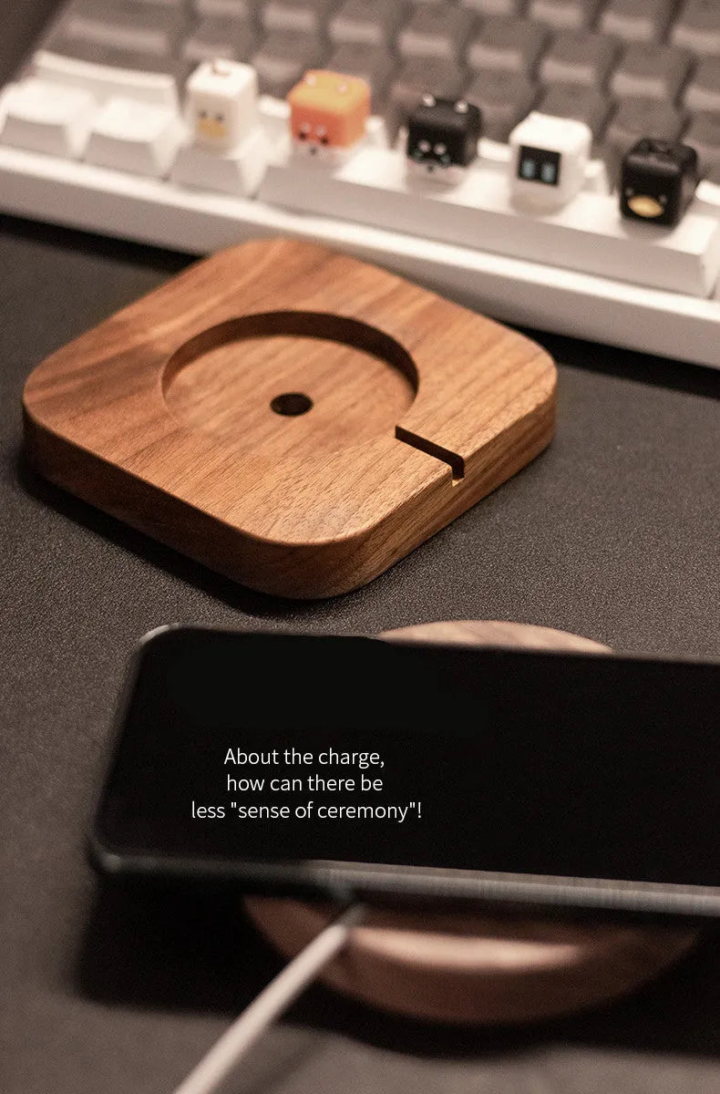 Solid walnut wood magnetic wireless charging bracket base for Magsafe iPhones on a desktop.