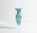 Colourful double layer blown glass vase in pink tone on a dining table with dried flowers