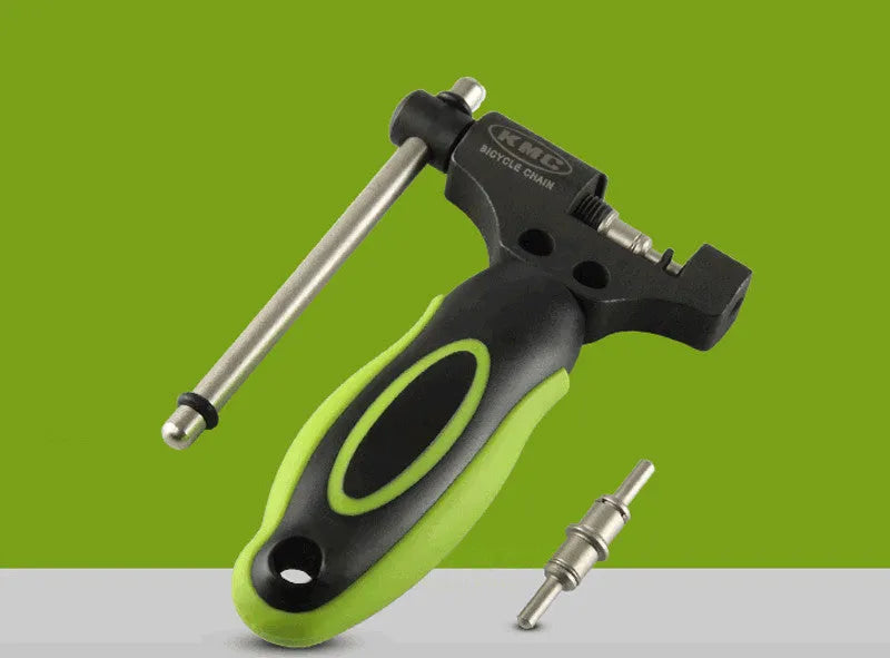 Green steel bicycle chain cutter with a double shaft device and a separate chain driver on a workbench.