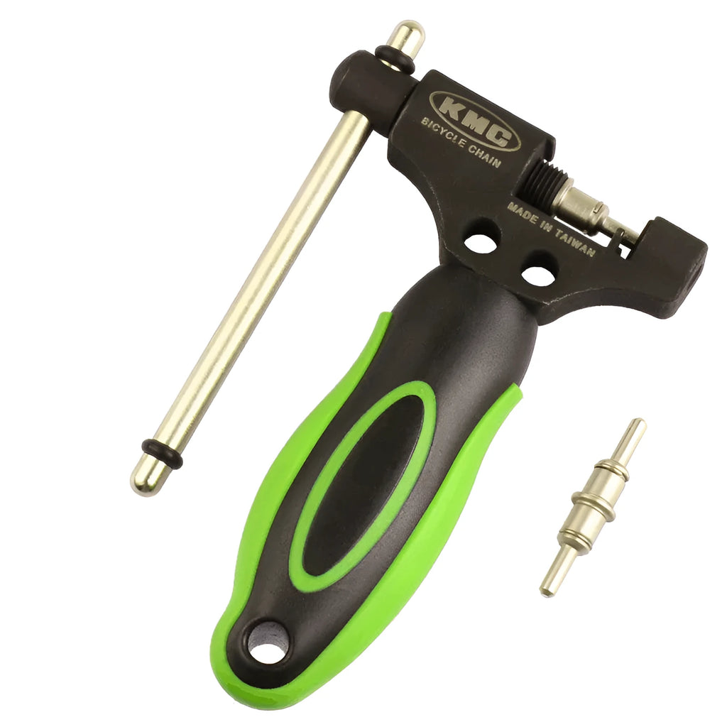 Green steel bicycle chain cutter with a double shaft device and a separate chain driver on a workbench.
