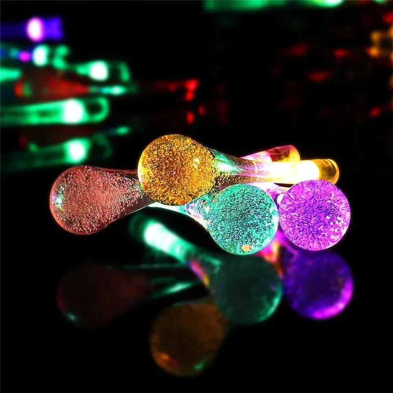 Solar-powered LED Water Drops string lights with ABS plastic pendants on a 6.5 metre wire for outdoor gardens.