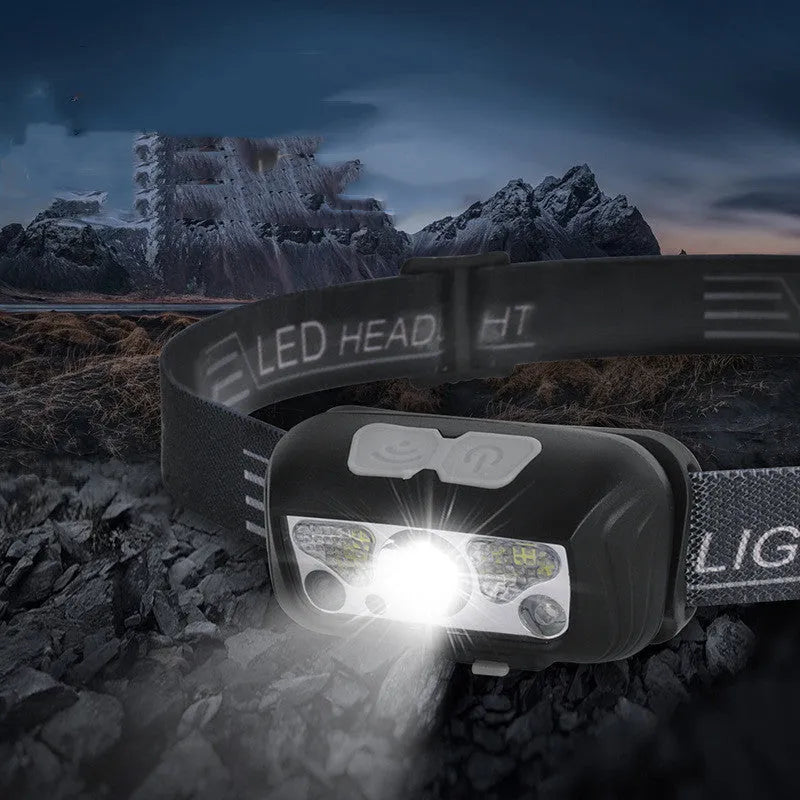 Black or blue LED sensor headlight with red running lights, shown with USB charging cable.