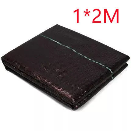 Black polyethylene weed-proof cloth laid on soil for farmland and garden weed suppression.