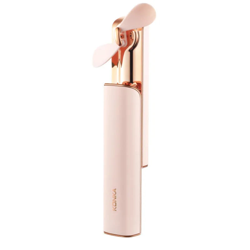 Small pink folding handheld fan with USB charging port and mechanical speed controls.