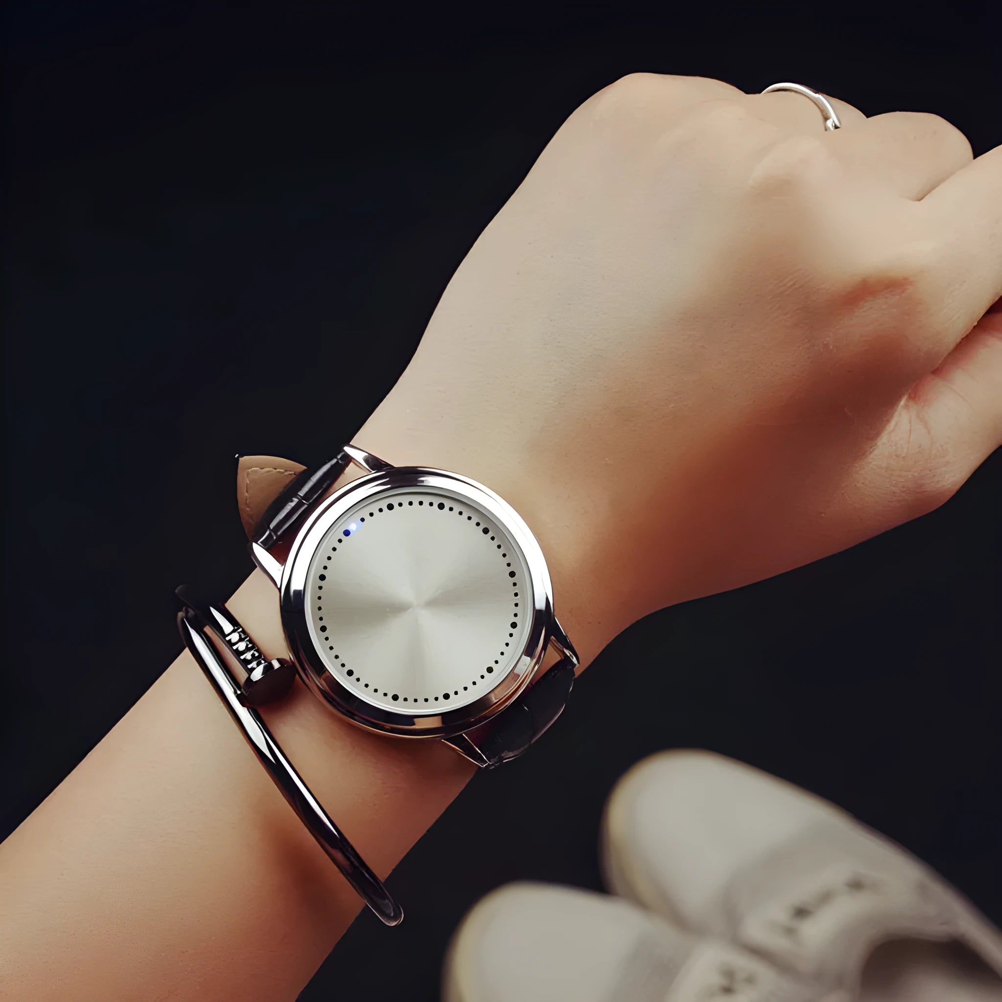 Electronic digital watch with blue light display showing numbers in black or white casing