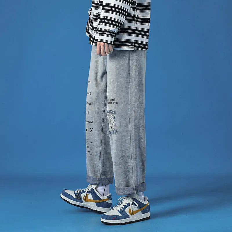 Men's loose fit washed cotton jeans in light blue with printed design and zipper fly, available in sizes M to 5XL