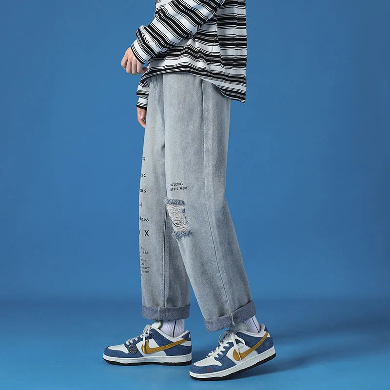 Men's loose fit washed cotton jeans in light blue with printed design and zipper fly, available in sizes M to 5XL