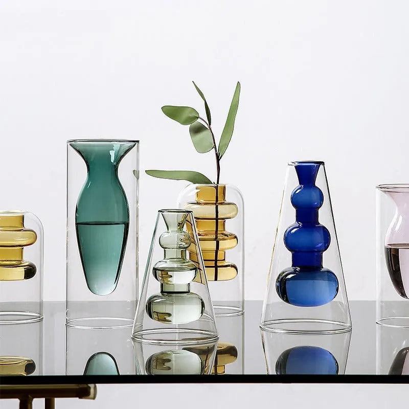 Colourful double layer blown glass vase in pink tone on a dining table with dried flowers