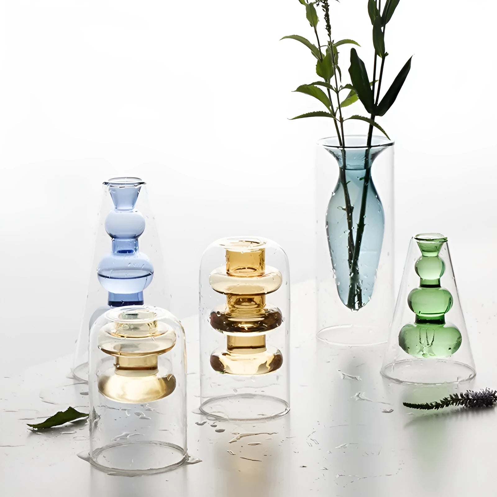 Colourful double layer blown glass vase in pink tone on a dining table with dried flowers