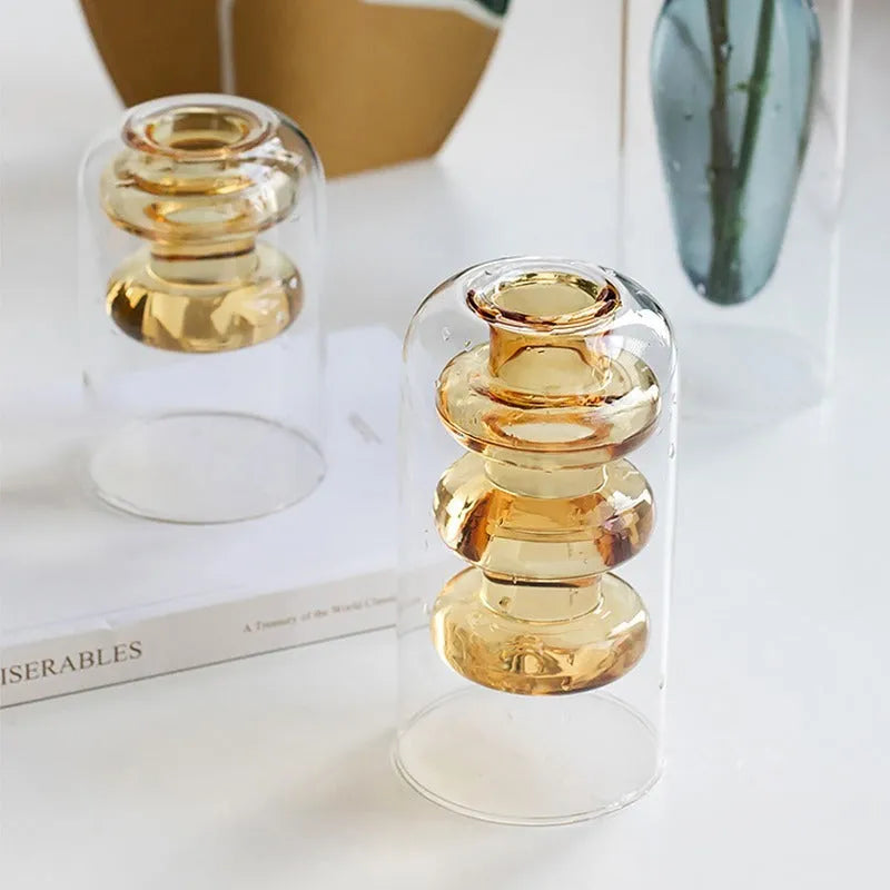 Colourful double layer blown glass vase in pink tone on a dining table with dried flowers