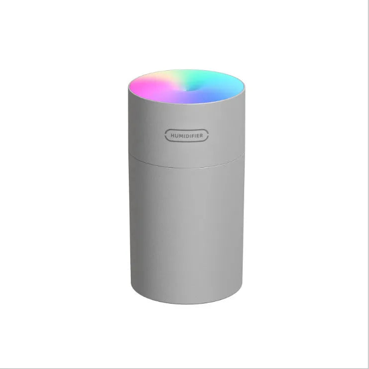 Pink USB mini humidifier with LED lights and water tank on desk