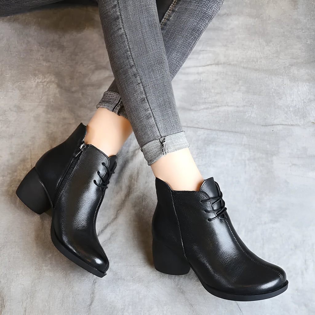 Women's black leather Martin ankle boots with a thick rubber heel and round toe.