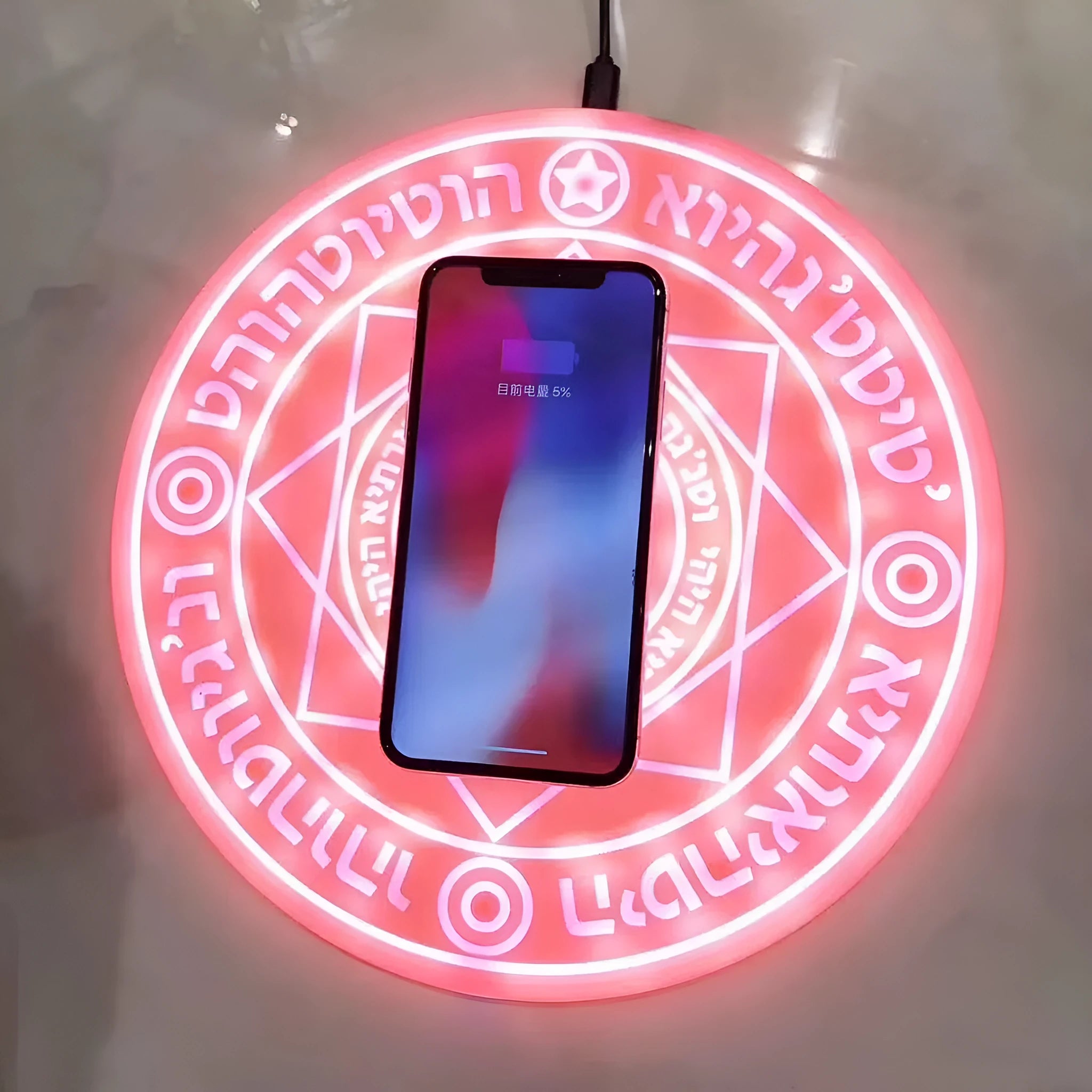 Square wireless phone charger with magic array pattern showing black colour option on desk surface