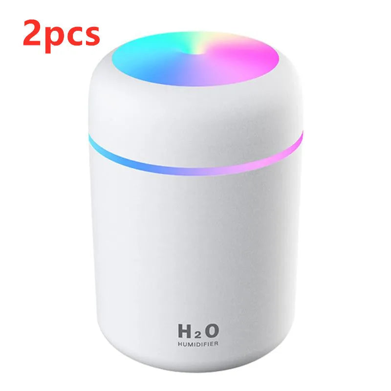 Pink USB mini humidifier with LED lights and water tank on desk
