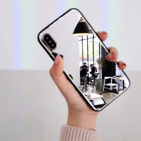 Black mirrored back cover phone case for Apple iPhone models on a table.