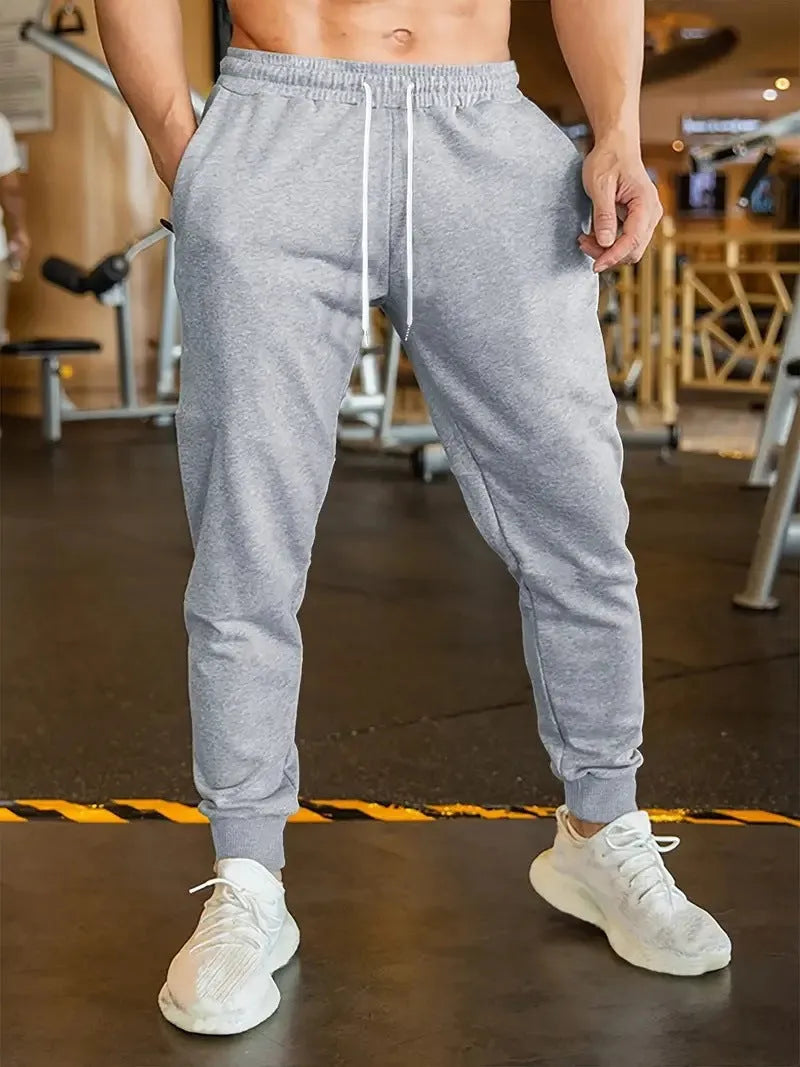 Men's loose fit linen-style trousers with a drawstring elastic waist, shown in a casual setting.