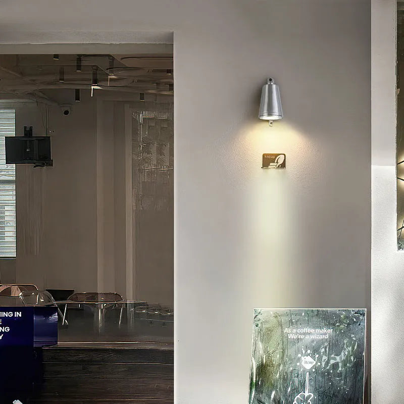 Industrial cast aluminum horseshoe wall lamp in sand black finish for outdoor door.