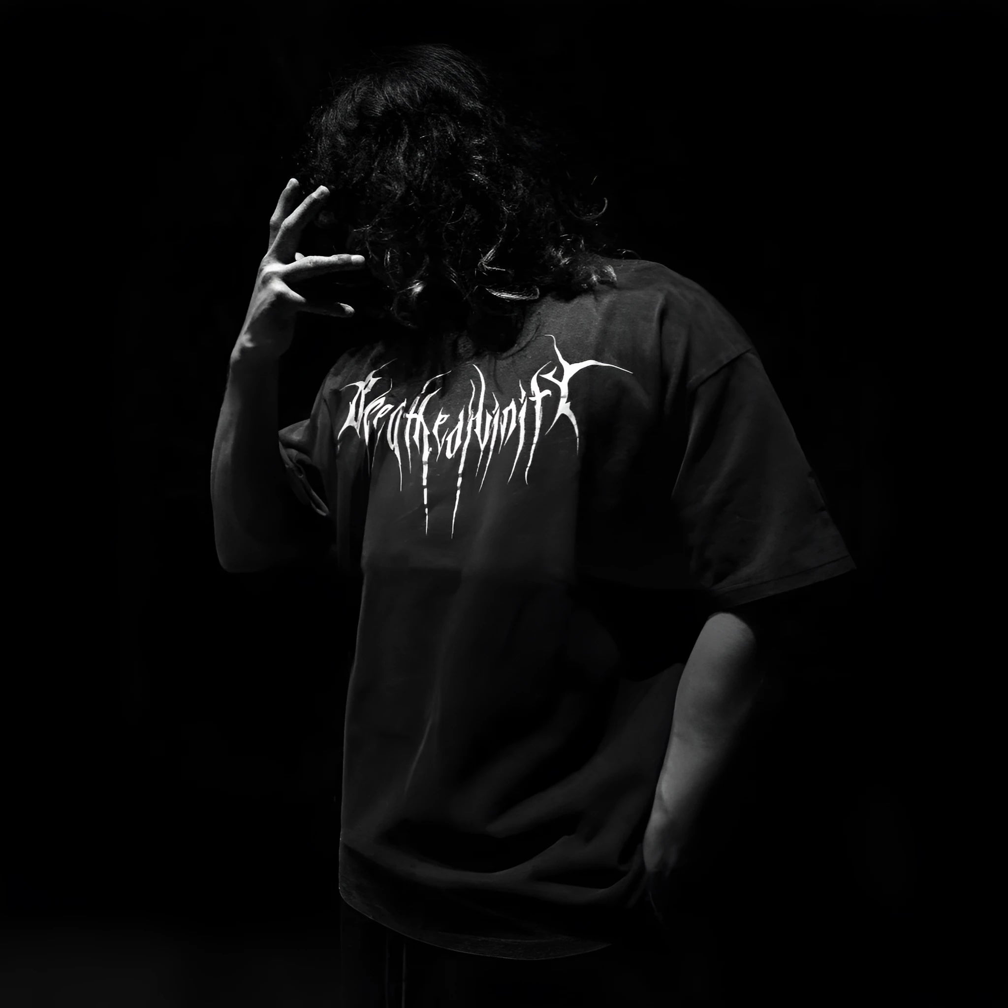 A man's loose-fit dark coloured cotton t-shirt with a gold gilding design detail on the front.