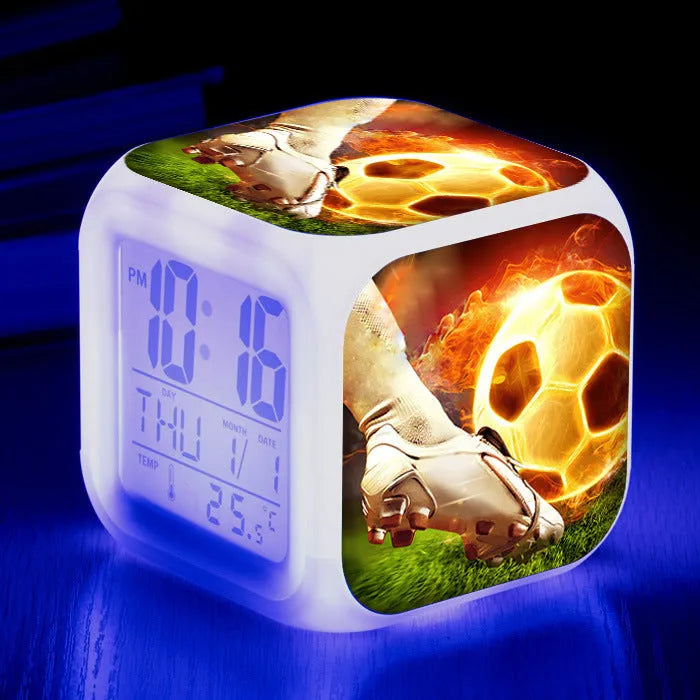 Square plastic alarm clock with a cartoon football pattern, showing silent vibrating alarm models.
