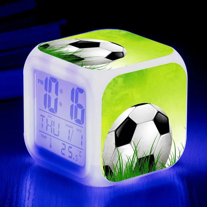 Square plastic alarm clock with a cartoon football pattern, showing silent vibrating alarm models.