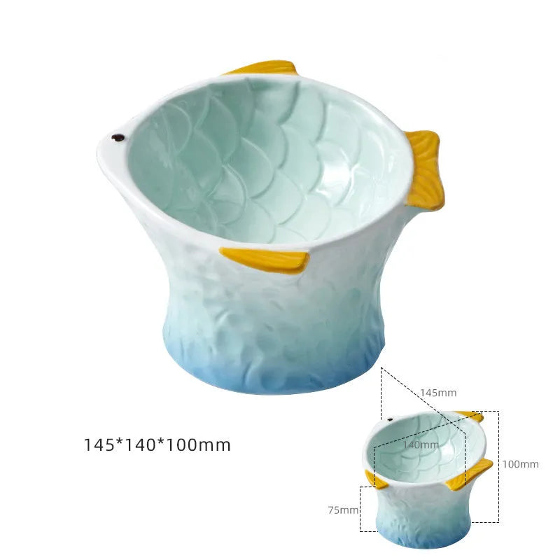 Blue ceramic fish-shaped cat bowl with tilted design and shallow eating surface on a plain background.