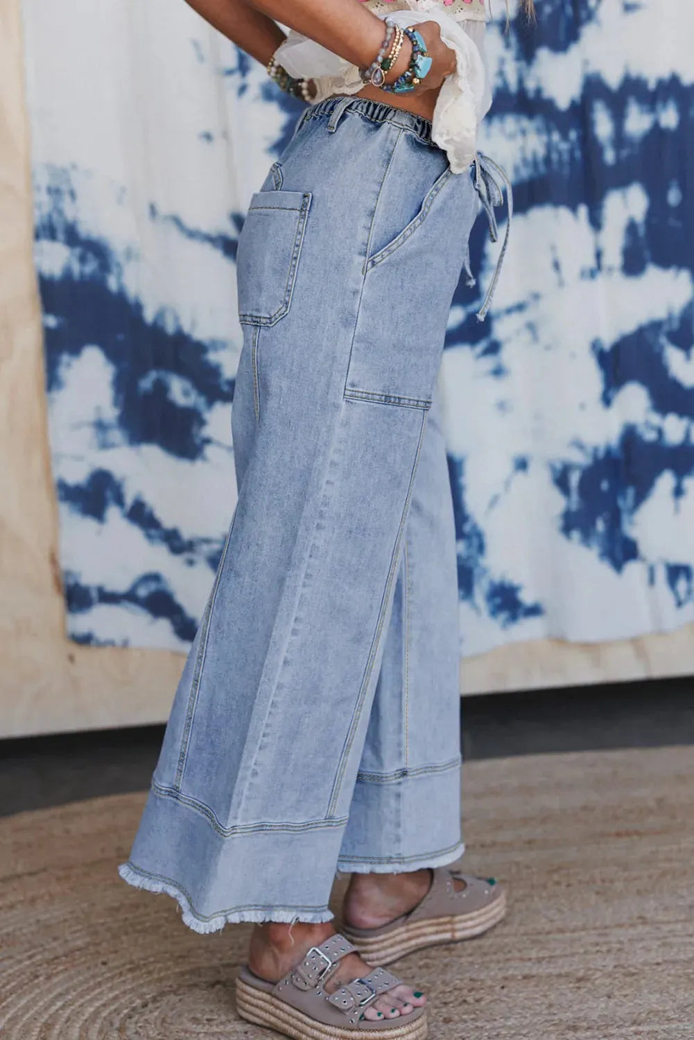 Beau blue wide leg denim trousers with drawstring waist, raw hem finish, and visible seam detailing