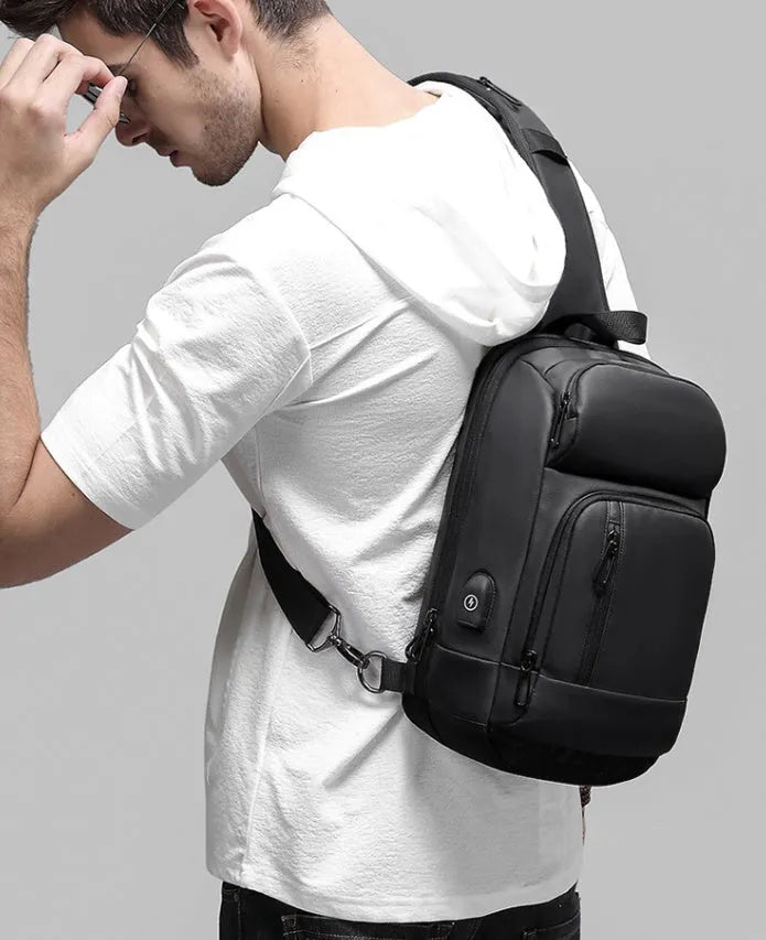 Black PVC outdoor shoulder bag showing internal organisation compartments and air cushion strap