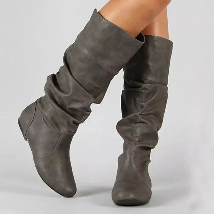 Women's black slip-on flat ankle boots with round toe and rubber sole.