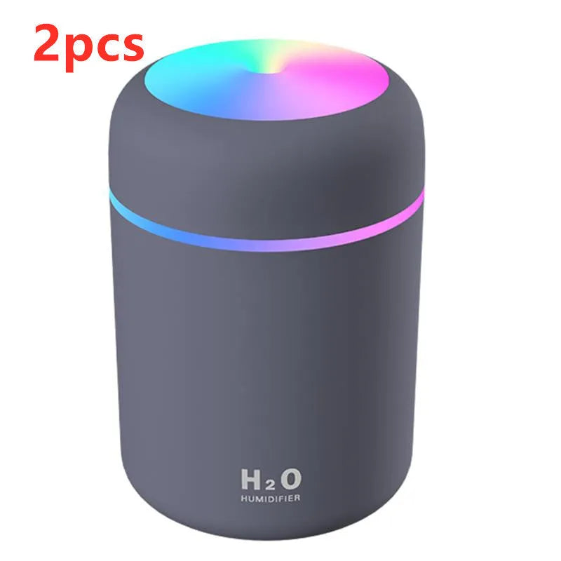 Pink USB mini humidifier with LED lights and water tank on desk