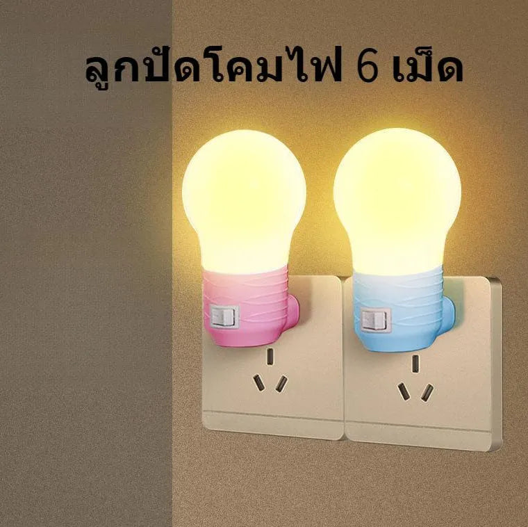 Plug-in bedside baby night light in white, blue, or pink shell with round design on a table