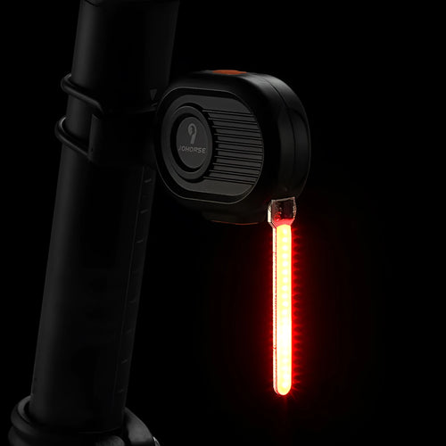 Bicycle rear safety taillight displaying a colourful running water or waterfall light effect on a black background.