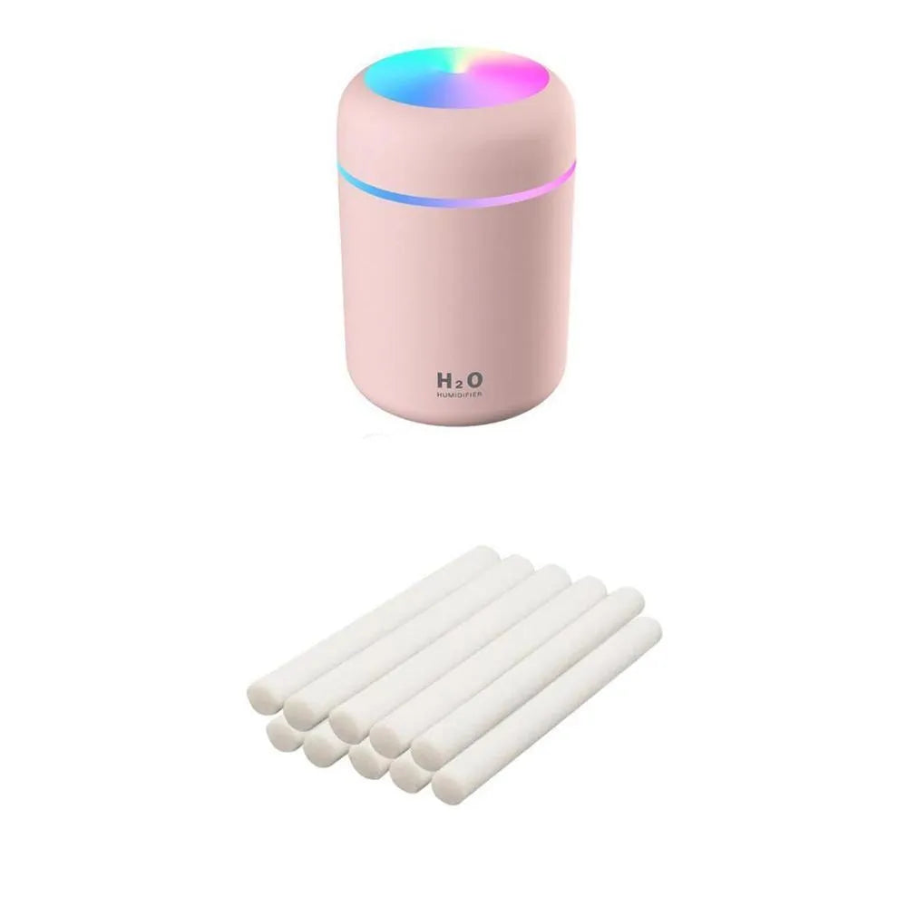 Pink USB mini humidifier with LED lights and water tank on desk