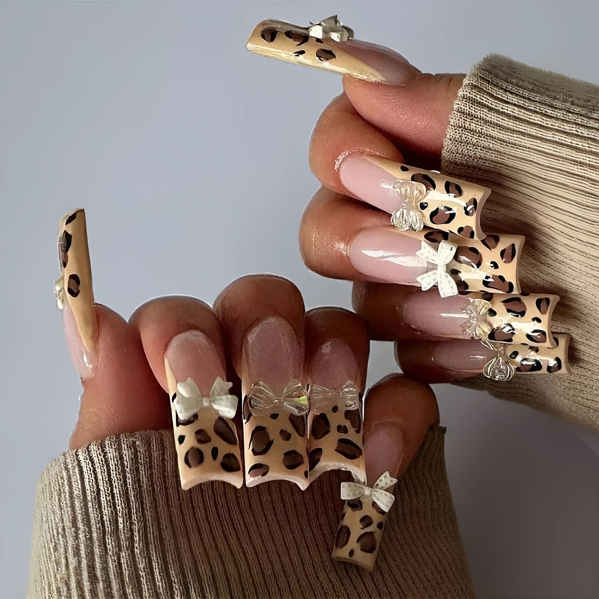 Leopard print butterfly design nail art stickers and gems on a white background.