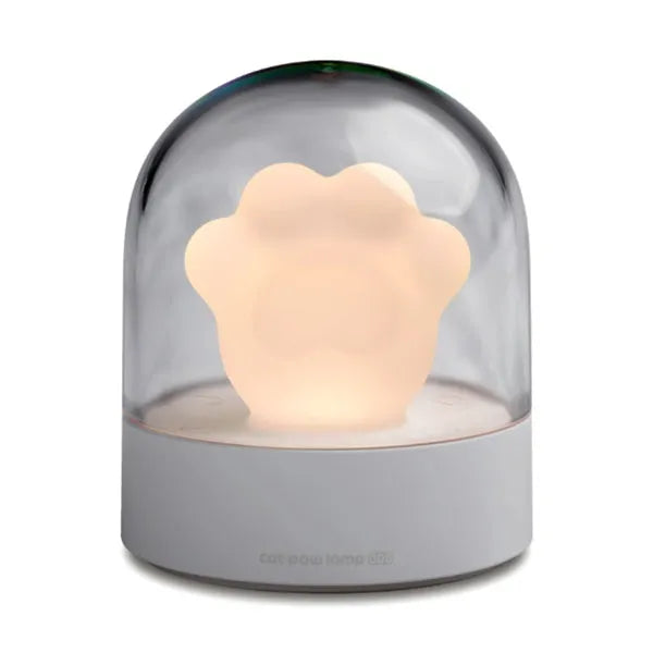Grey or pink cat paw shaped USB rechargeable night light with music box function on a desk.