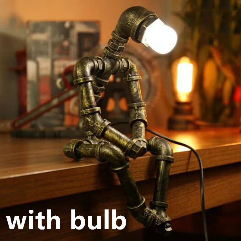 Green bronze vintage robot table lamp with industrial iron pipe design on wooden desk