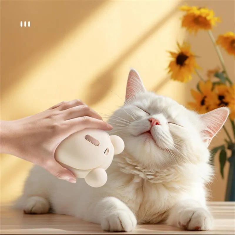 Pink rechargeable pet grooming brush with spray button and removable silicone comb head