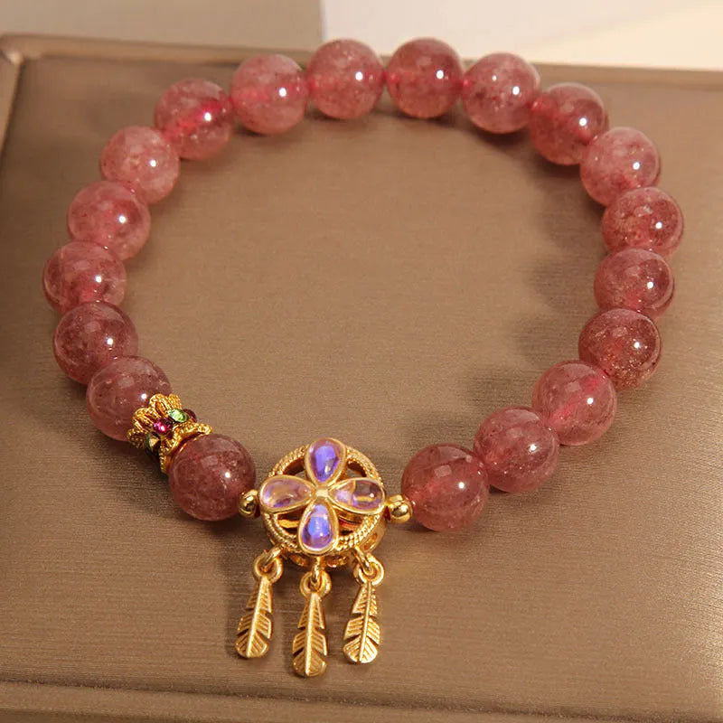 Women's bracelet with strawberry quartz beads and crystal accents featuring four-leaf dream catcher pendant