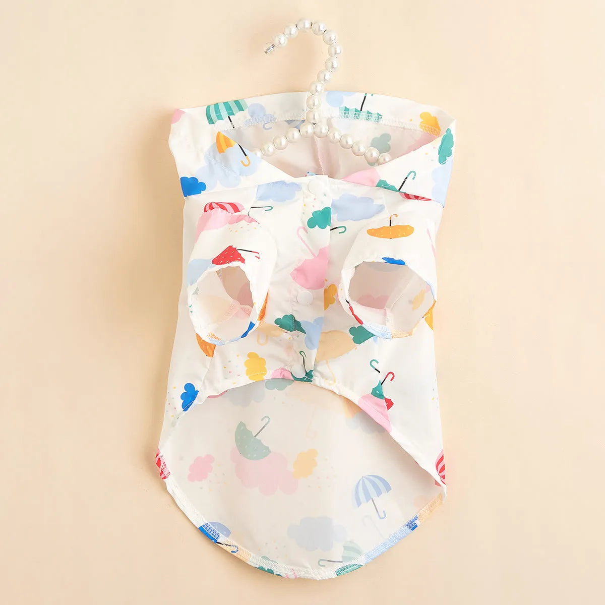 Colourful cartoon umbrella print dog raincoat in polyester fabric.