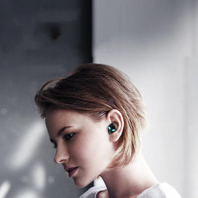 Alien-themed Creative Outer T8 Starman black wireless earbuds with red LED lights next to charging case.