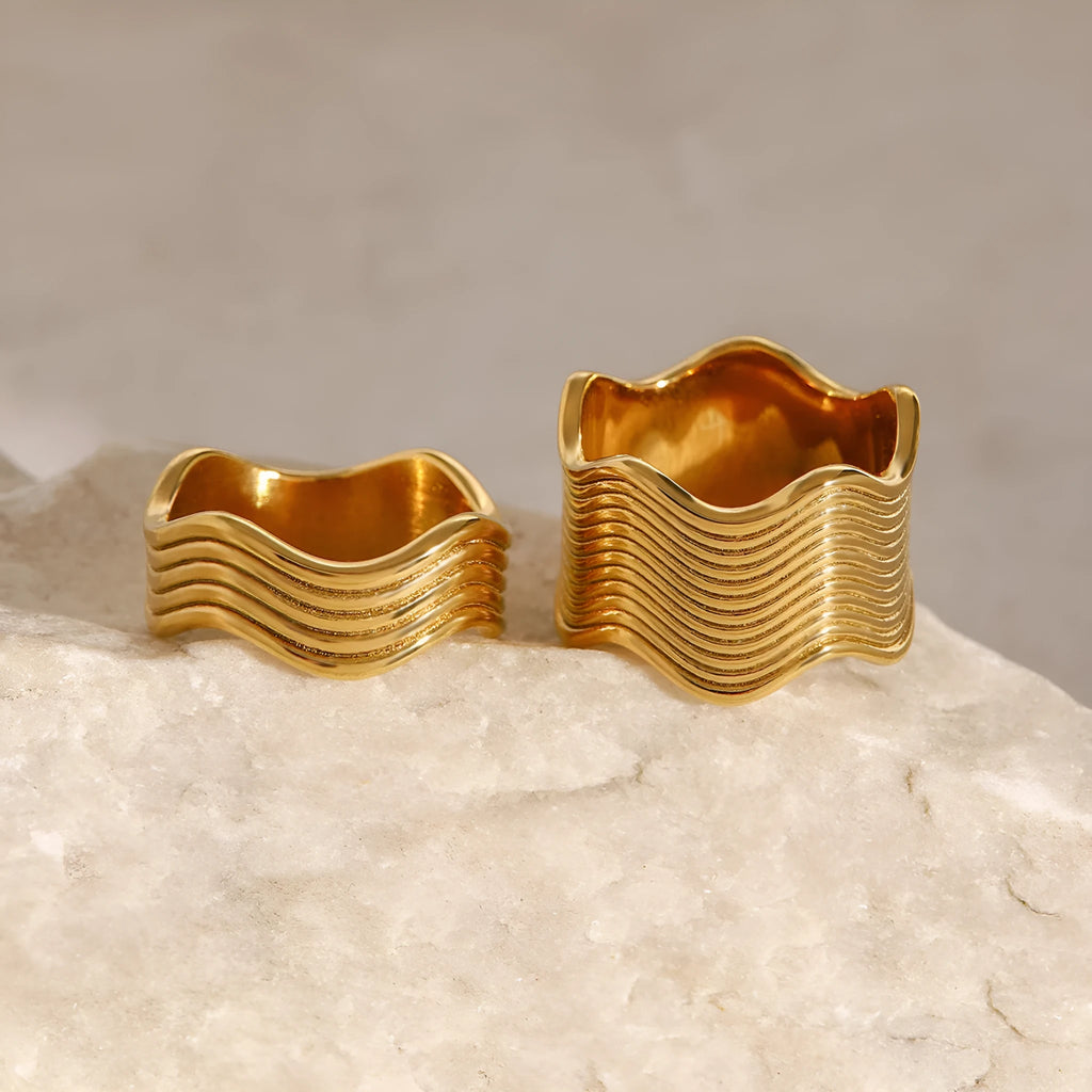 A stainless steel women's ring with a wide, geometric wave design in a Korean style.